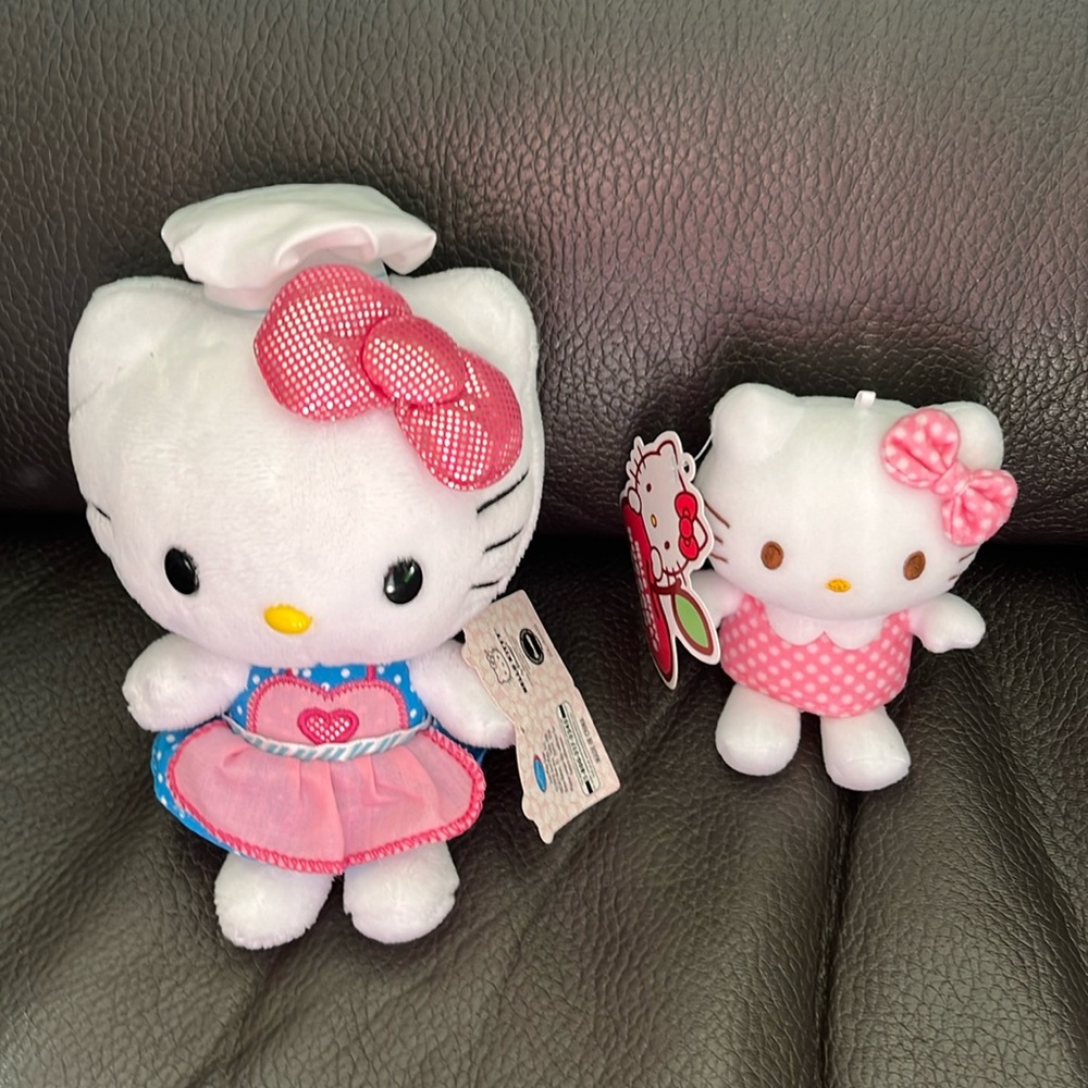 Two hello kitty stuffed animals with polka dot outfits